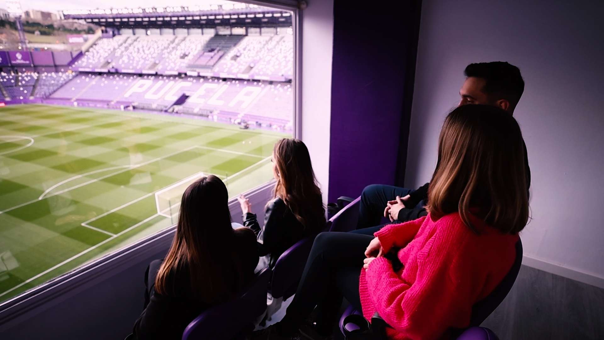 Grupo de personas sentadas disfrutando de las vistas al terreno de juego